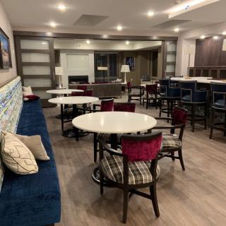 A modern dining area with round tables and mixed seating options.