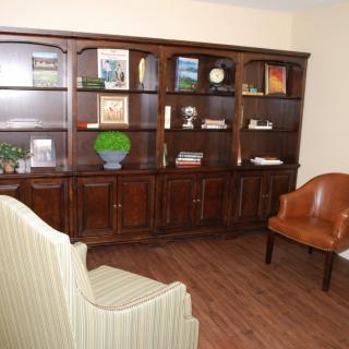 A cozy living room with wooden bookshelves and comfortable seating.