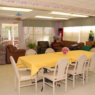 A cozy living and dining area with a yellow tablecloth and comfortable seating.