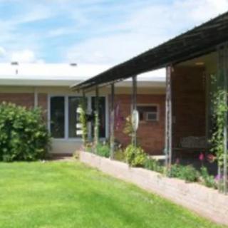 A single-story house with a well-maintained lawn and a garden patio.