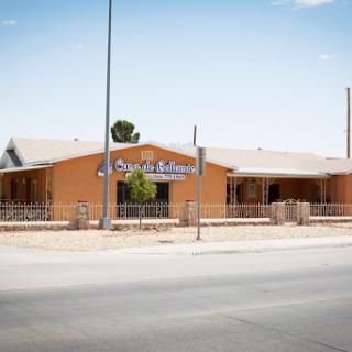 View of a commercial building with orange exterior and signage from the roadside.