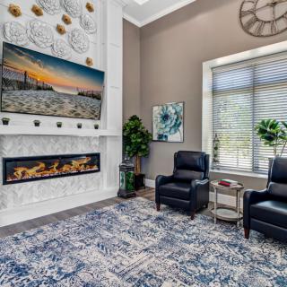 A modern living room featuring a decorative fireplace, artwork, and comfortable seating.