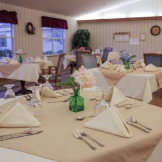 A neatly arranged dining room with elegantly folded napkins and a cozy atmosphere.