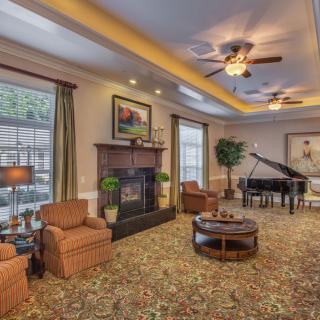 A cozy living room with a fireplace, piano, and comfortable seating.