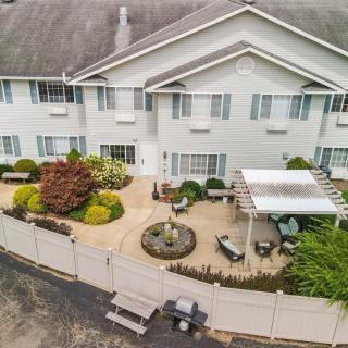 Aerial view of a house with a landscaped backyard featuring a patio, pergola, and garden.