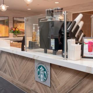 Interior view of a Starbucks coffee counter with drink dispensers and cups.