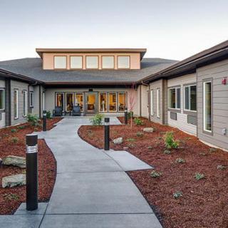 A modern building with a landscaped pathway leading to the entrance.