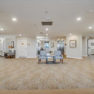 A spacious lobby area with seating and artwork on the walls.