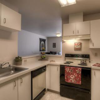 A modern kitchen with light cabinets and appliances.