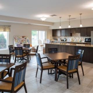 A bright and spacious dining area featuring modern furnishings and an open kitchen.