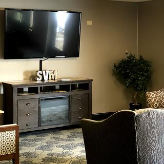 A cozy living room with a mounted TV and stylish furniture.