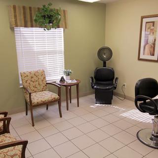 A cozy hair salon interior with seating and a hair dryer.