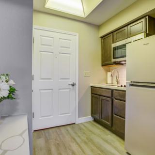 A modern kitchen with wooden cabinets, a refrigerator, and a microwave.