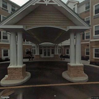 The image shows the entrance of a building with a covered canopy supported by columns.