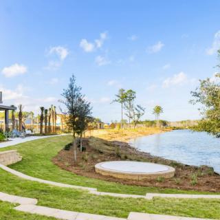 A scenic view of a park with a lake and greenery.