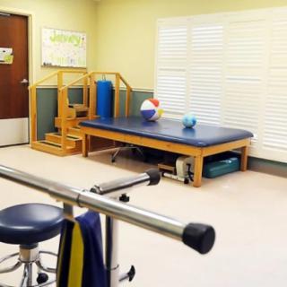 A physical therapy room equipped with exercise equipment and a treatment table.
