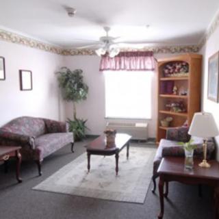 A cozy living room with classic furniture, including a sofa, coffee table, and bookshelf.