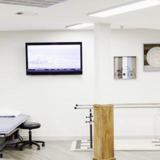 A modern rehabilitation clinic with exercise equipment and a treatment table.