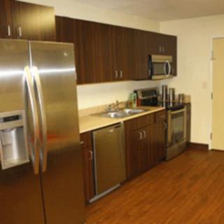 A modern kitchen featuring stainless steel appliances and wooden cabinets.