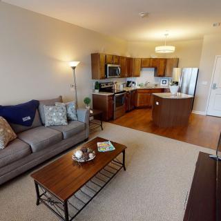 A modern apartment featuring an open floor plan with a cozy living room and sleek kitchen.