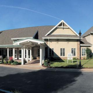 A modern residential building with a welcoming entrance and landscaped surroundings.