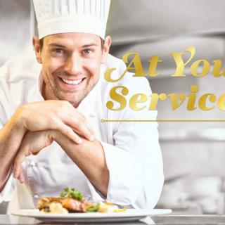 A smiling chef presenting a dish in the kitchen with the text 'At Your Service'.