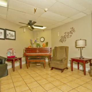 A cozy living room with a piano and comfortable seating.
