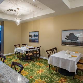 A small, elegantly decorated dining room with tables set for a meal.