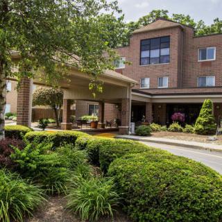 A hotel entrance surrounded by lush greenery and landscaped gardens.