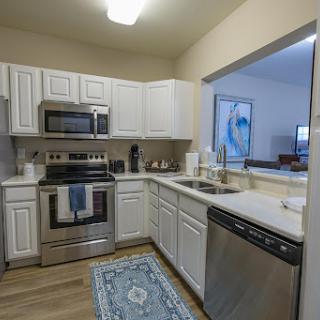 A contemporary kitchen featuring white cabinetry and stainless steel appliances, creating a clean and inviting cooking space.