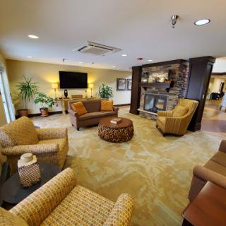 A cozy lobby area featuring comfortable seating, a television, and a fireplace, perfect for relaxation.