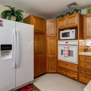 A cozy kitchen with wooden cabinets, a white refrigerator, and built-in appliances.