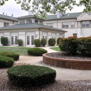A landscaped garden area in front of a large building with green roofs and plenty of windows.