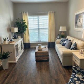 A cozy living room featuring a light-colored sofa, decorative pillows, and warm yellow curtains that invite natural light.
