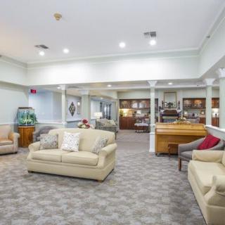 A spacious living room with comfortable sofas and bright ceiling lights.