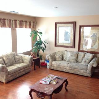 A cozy living room with two sofas, a coffee table, and framed artwork on the walls.