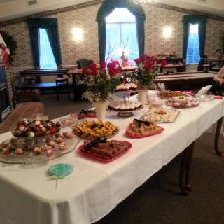 A beautifully arranged dessert table featuring an array of sweets and decorative flowers, perfect for a celebratory event.