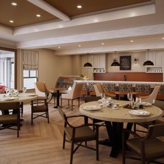 An elegant restaurant interior with neatly set tables and comfortable seating.