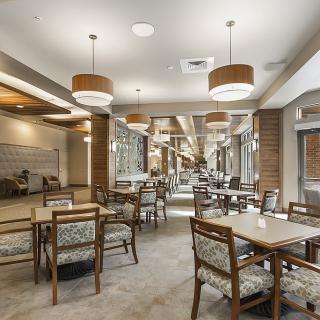 A modern dining area with neatly arranged tables and chairs, complemented by stylish ceiling lights.