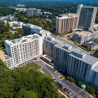 Aerial view of an urban area featuring multiple buildings surrounded by greenery.