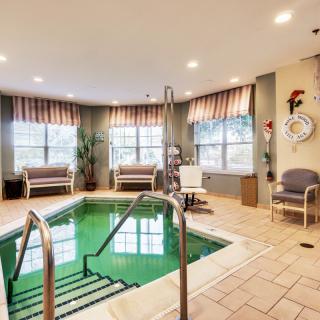 A cozy indoor therapy pool with seating and natural light.