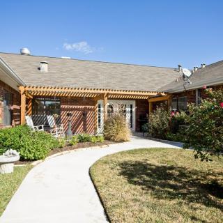 A charming house with a well-maintained garden and a winding pathway leading to the entrance.