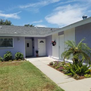 A suburban single-story house with a small front garden and sidewalk.