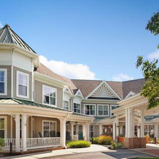 A Victorian-style residential building with a well-maintained exterior and multiple gables under a clear blue sky.