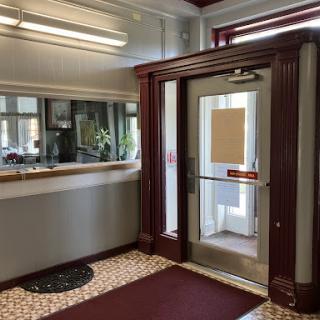 A welcoming lobby area featuring a glass door, an information counter, and decorative elements.