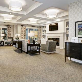 A modern and elegantly decorated living room featuring comfortable seating, a fireplace, and soft lighting.