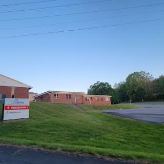 A view of a building with signage set against a clear blue sky and lush green grass.