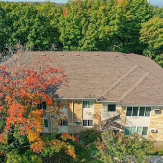 A cozy residential building surrounded by vibrant autumn foliage.