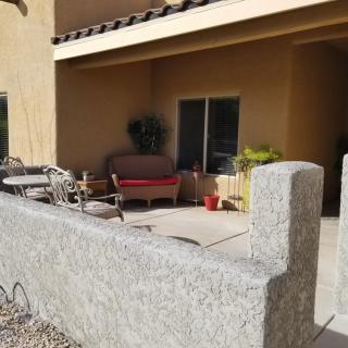 A sunny patio with outdoor furniture and potted plants.