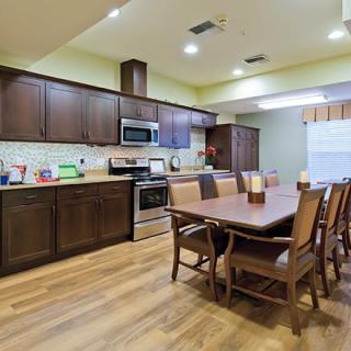 A spacious kitchen and dining area with wooden cabinets and a large dining table.